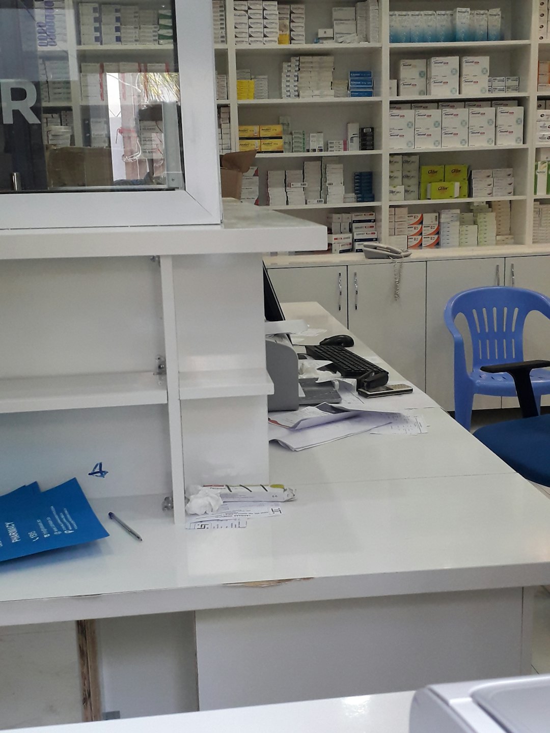 Apotheken-Theke mit Medikamenten und Computerarbeitsplatz.